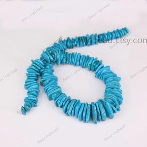 以下が含まれることがあります： ターコイズブルーのチップビーズのストランド。各チップはサイズと形が異なります。ビーズはネックレスやブレスレットを作るために糸でつなげられています。ビーズは、茶色と黒のマーブル模様が入った明るいターコイズブルーです。ビーズはすべて天然で、ユニークな形と質感を持っています。
