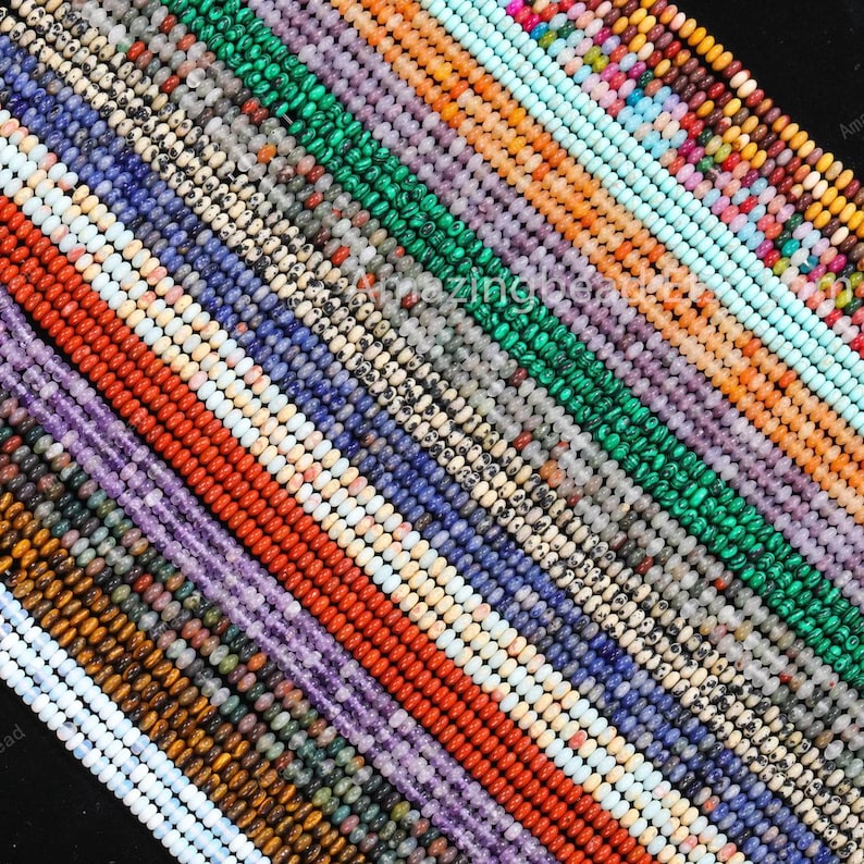 May include: A selection of gemstone beads in various colours, arranged diagonally. The beads display hues of blue, green, red, purple, and orange. The image includes the text "Amazing Beads".