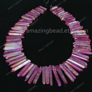 Peut inclure: Un brin de perles de cristal pointues iridescentes roses. Les perles mesurent environ 1,2 cm de long et ont une forme pointue facetée. Les perles sont enfilées sur un cordon élastique transparent.