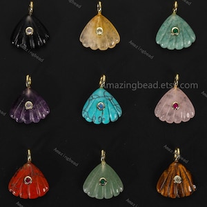 May include: A collection of nine gemstone pendants in various colors, including black, yellow, green, purple, turquoise, pink, red, and brown. Each pendant has a fan-like shape with a gold-colored bail and a small, central gemstone.