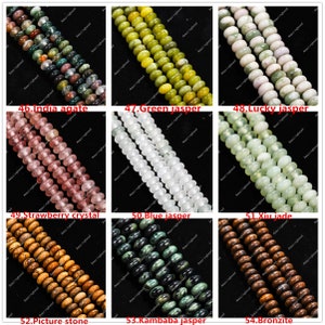 May include: A selection of gemstone bead strands in shades of green, pink, and brown. The image shows various bead types, including "India agate," "Green jasper," and "Strawberry crystal." The beads are round and polished, suitable for jewellery making.
