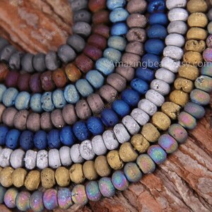 May include: A collection of colorful, textured, agate beads in various shades of blue, gray, gold, and brown. The beads are arranged in a circular pattern, showcasing their unique, natural beauty.