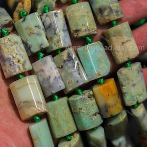 Può includere: Primo piano di una collana di perline rettangolari di pietra preziosa verde chiaro. Le perline sono infilate su un cordoncino verde e presentano variazioni di colore, tra cui beige, grigio e giallo. Il testo "Amazingbead.etsy.com" è visibile.