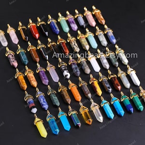 May include: A collection of 40 gemstone point pendants with gold-tone caps. The pendants are in various colours and patterns, including clear, blue, green, red, orange, brown, and purple.