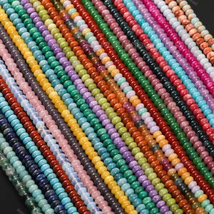 May include: A collection of colorful gemstone beads in various shades, including blue, green, yellow, orange, purple, and red. The beads are strung together, creating a vibrant and diverse display of natural stone jewelry components.