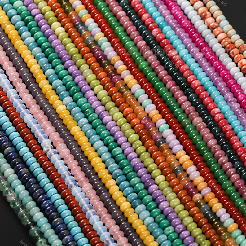 May include: A collection of colorful gemstone beads in various shades, including blue, green, yellow, orange, purple, and red. The beads are strung together, creating a vibrant and diverse display of natural stone jewelry components.