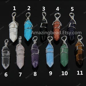 May include: Eleven wire-wrapped crystal point pendants, each with a silver bail. The crystals are clear, rose quartz, amethyst, blue, white, red, black, green, and tiger's eye.