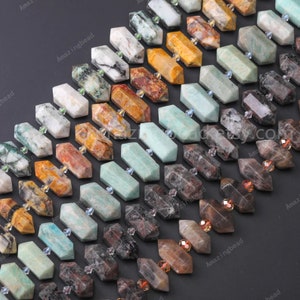 May include: A collection of various coloured gemstone beads in a faceted, hexagonal shape. The beads are arranged in rows, with each row featuring a different colour and pattern. The beads are made of natural stones, such as aventurine, agate, and jasper.