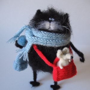Chat pelucheux noir avec la souris