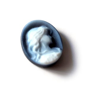 May include: A blue cameo featuring a white profile of a woman's face.