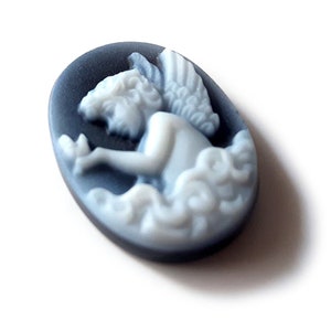 May include: A white cameo featuring a cherub with wings, set against a black oval background.