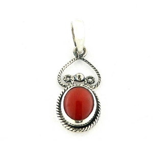 May include: A silver pendant with a red coral stone set in a decorative silver frame. The pendant has a bail for attaching to a chain.