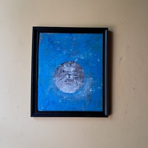 Peinture de phoque sur carton, visage circulaire levant les yeux dans l'eau, grands yeux larmoyants, bouche ouverte et moustaches. chat de mer