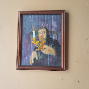 Una figura encapuchada que sostiene un elaborado candelabro con forma de grifo. La vela está encendida. La figura es misteriosa.