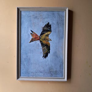 Schilderij in gotische stijl van een rode wouw tijdens de vlucht met zwarte vleugels en rode staart die er imposant en prachtig uitziet. Lichtblauwe achtergrond