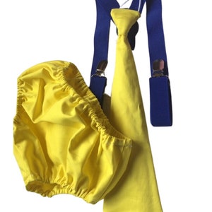 Peut inclure: Une tenue de bébé jaune avec une cravate assortie et des bretelles bleues. La tenue est en coton doux et est parfaite pour une occasion spéciale.