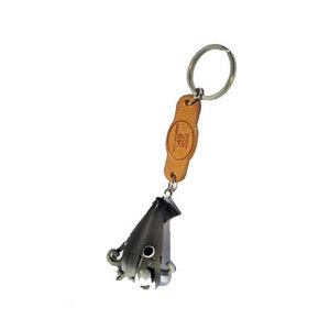 May include: A silver-colored squid keychain with a brown leather tag that says "Leather Craftsmanship". The keychain has a silver ring for attaching to keys.