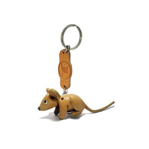 May include: A tan leather mouse keychain with a silver key ring and a tan leather tag with a logo.
