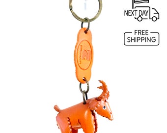 May include: A brown leather keychain featuring a small, detailed goat figurine. The keychain also includes a brown leather oval tag with the text "Leather Crafts" in white.