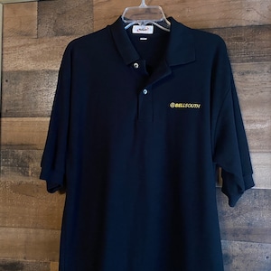 May include: A black polo shirt with a gold embroidered logo that says "@BELLSOUTH".