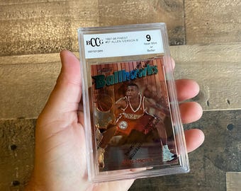 May include: A 1997-98 Finest Allen Iverson basketball card, graded BCCG 9, encased in a protective holder. The card features a player image with the text "Ballhawks" and "Sixers".