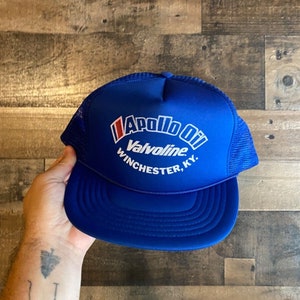 Op de afbeelding: Blauw-witte trucker cap met de tekst "Apollo Oil Valvoline Winchester, KY."