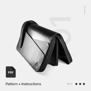 Puede incluir: Cartera de cuero negro con cierre de cremallera y asa. La cartera está doblada por la mitad y la cremallera está abierta. El texto "PDF" está en un cuadro blanco en el lado izquierdo de la imagen. El texto "Pattern + Instructions" está debajo del cuadro. El texto "Difficulty" está en el lado derecho de la imagen con tres estrellas debajo.