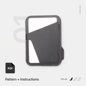 May include: A minimalist, dark gray leather wallet with a card slot and a triangular logo. The wallet is stitched around the edges and has a simple, modern design. The image also includes the text "Pattern + Instructions" and a PDF icon.
