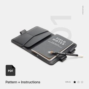 May include: A black leather notebook cover with a pocket and a pen holder. The cover is open to reveal a Field Notes notebook and a white pencil. The text "FIELD NOTES" is printed on the notebook. The image includes the text "PDF Pattern + Instructions" and "Difficulty".