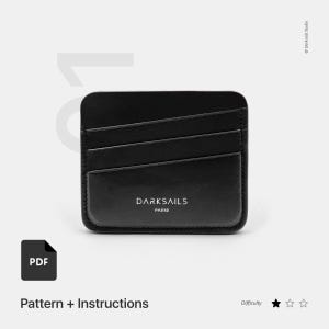 May include: A black leather cardholder with three card slots. The cardholder has rounded corners and the text "DARKSails PARIS" printed on the front. The image also includes a PDF icon and the text "Pattern + Instructions".