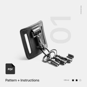 May include: Black leather key holder with a metal clip and three keys attached. The key holder is designed to be attached to a belt. The image includes the text "Pattern + Instructions" and "Difficulty" with three stars.