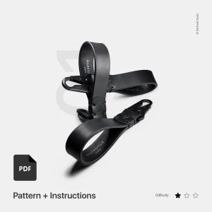 Puede incluir: Correa de cuero negra con una hebilla plateada y el texto "DARKS/AILS PARIS" impreso en ella. La correa está doblada por la mitad y la hebilla es visible. La correa es un patrón y unas instrucciones de bricolaje.