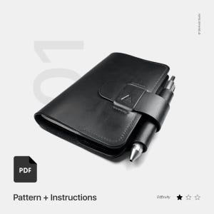 May include: A black leather journal with a pen holder and a silver pen. The journal is closed and has a strap with a metal clasp. The image includes the text "Pattern + Instructions" and a PDF icon.