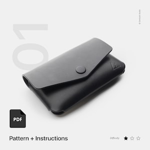 May include: Black leather wallet with a flap closure and a single button. The wallet is laying on a white surface. The image includes the text "Pattern + Instructions" and a PDF icon.