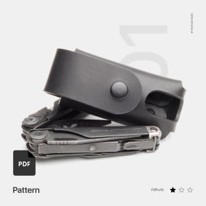 May include: A black multi-tool with a black leather sheath. The multi-tool is partially open, revealing various tools. The sheath has a snap closure. The word "Pattern" is visible in the image.