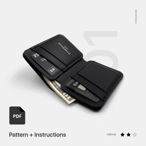 Może przedstawiać: Czarny skórzany portfel o konstrukcji składanej. Portfel jest otwarty i pokazuje banknot, karty kredytowe i małą kieszeń. Portfel ma wytłoczony napis "DARKSAILS" na przodzie.