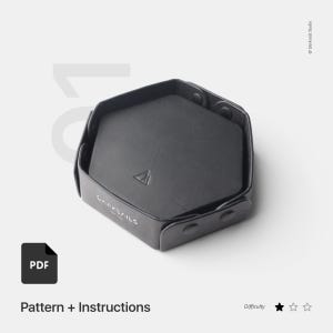 May include: A black leather hexagonal tray with a triangular logo and the text "DARKSAILS LONDON". The tray is open, revealing a dark interior. The image includes a PDF icon and the text "Pattern + Instructions".