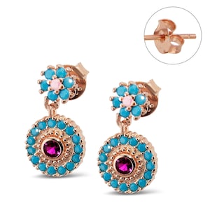 May include: Rose gold earrings with a turquoise and pink flower design and a round turquoise and pink stone in the center.