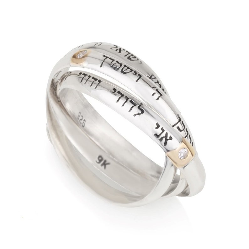 May include: A silver and gold triple band ring with Hebrew writing and two small diamonds. The ring is 9K.