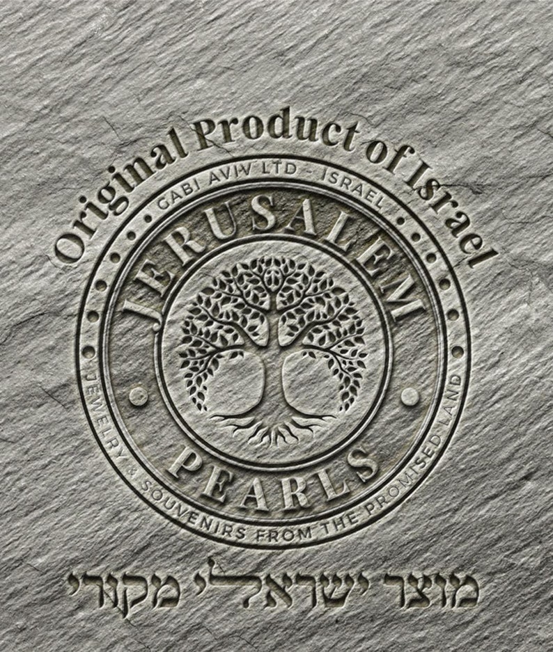 May include: A circular stone emblem with the words "Original Product of Israel" and "Jerusalem Pearls Jewelry & Souvenirs from the Promised Land" surrounding a tree of life design. The text "מוצר ישראלי מקורי" is below the emblem.