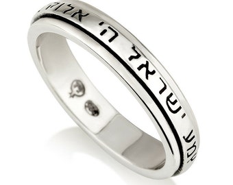 May include: A silver ring with a Hebrew inscription around the band. The inscription reads "Shema Yisrael Adonai Eloheinu Adonai Echad" which translates to "Hear O Israel, the Lord our God, the Lord is One."