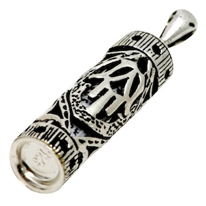 May include: A silver pendant in the shape of a scroll with intricate designs. The scroll is open and has a small piece of paper inside. The pendant is about 2 inches long.