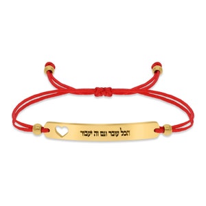 May include: Red string bracelet with a gold bar charm that says "Hakol S'vara Letova" in Hebrew. The charm has a heart cut-out.
