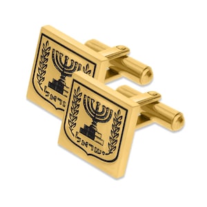 May include: Gold cufflinks with a black enamel design of the Israeli coat of arms, featuring a menorah, olive branches, and the Hebrew text "ישראל".