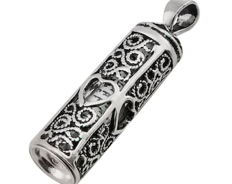 May include: Silver pendant in the shape of a cylinder with an intricate filigree design. The pendant has a heart-shaped opening that reveals a small scroll inside.