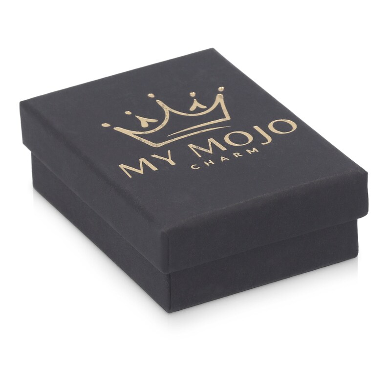 May include: A black gift box with a gold crown and the text "MY MOJO CHARM" printed on the top.