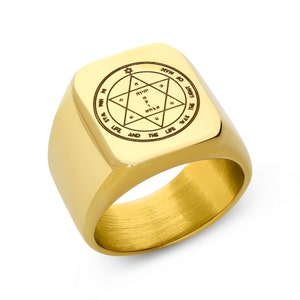 May include: A gold signet ring with a square top featuring a Hebrew inscription and a six-pointed star. The inscription reads "IN WIM WAS LIFE AND THE LIFE WAS THE LIGUE HOT."
