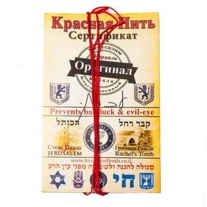 May include: A red string certificate with the text "Красная Нить" (Red String) and "Сертификат" (Certificate) in Russian. The certificate also includes the text "Оригинал" (Original) in Russian, "Prevents bad luck & evil-eye" in English, and Hebrew text. The certificate is tied with a red string.