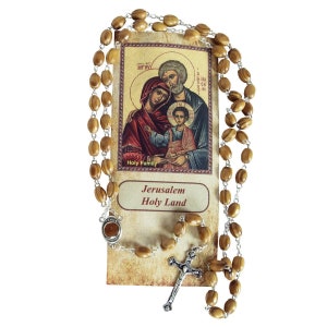 May include: Olive wood rosary beads with a silver crucifix and a Holy Family icon card. The card features a depiction of the Holy Family with the text "Holy Family" and "Jerusalem Holy Land".
