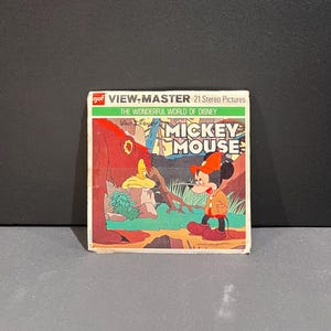 May include: A vintage View-Master packet featuring Mickey Mouse from the Wonderful World of Disney. The box has a green and white top with the text "VIEW-MASTER 21 Stereo Pictures". The front shows Mickey Mouse in a red outfit.